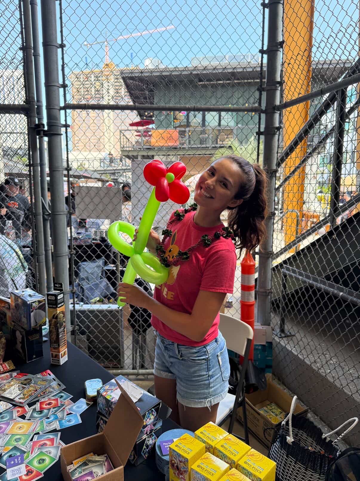 Young attendee with a balloon flower at a vendor table during the Keep It Aloha Card Show — families and kids are a big part of the modern card show crowd
